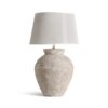 Lámpara de sobremesa de estilo provenzal fabricado en cerámica en color tonos claros con acabado envejecido combinado con algodón en color gris con acabado jaspeado.